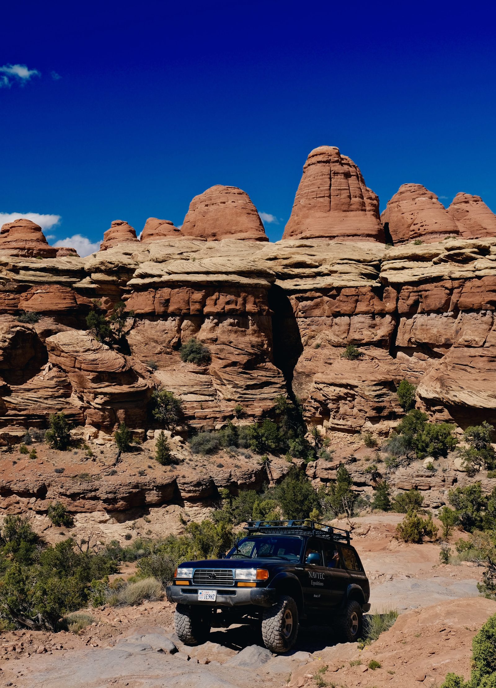 A NAVTEC 4x4 tour group taking in a red rock overlook inside a national park